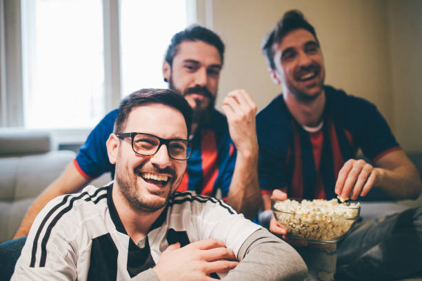 istock Male football supporters eating popcorn 950020406