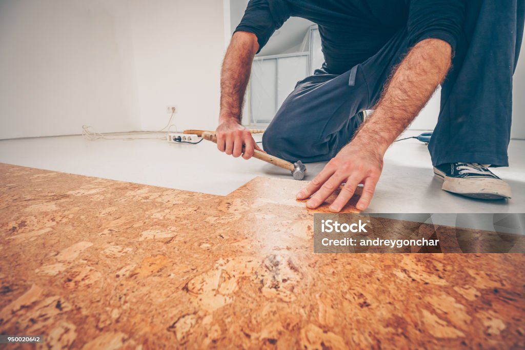 Master picks a series of cork floor cork flooring with a hammer Cork - Material Stock Photo