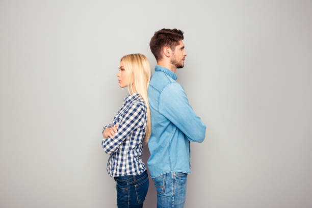 istock Man and woman with crossed hands standing back to back 950021356