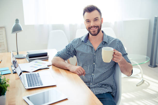 istock happy young businessman having break and drink coffee at workplace 950026746
