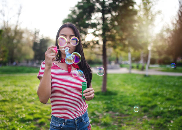istock Girl blowing bubbles in the park 950037042