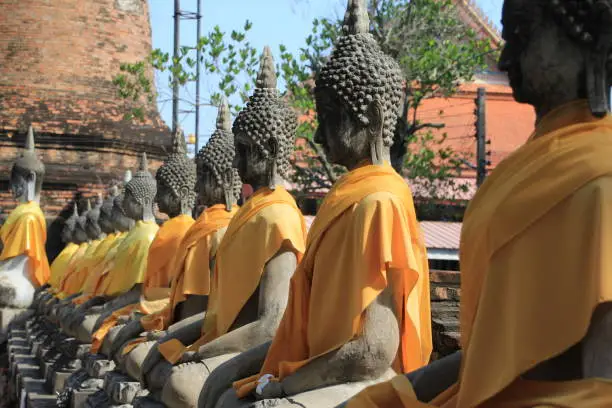 Stone Buddha statues wrapped in golden robes in a Thailand temple