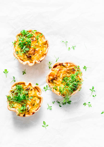 istock Mini savory pie with chicken, leek, cheese on light background, top view. Delicious appetizer, snack, breakfast, tapas 950043942