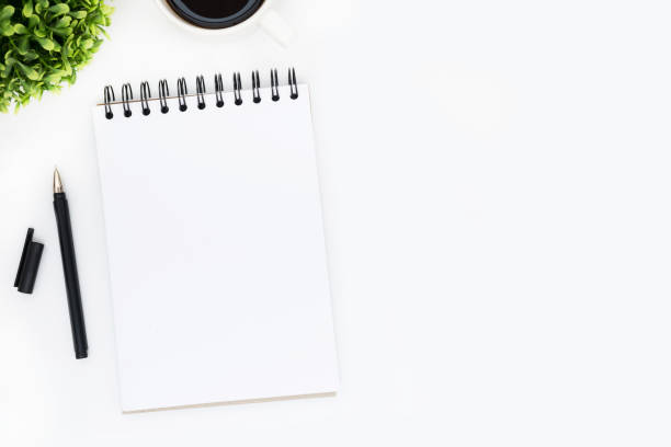 istock Blank notebook page is on top of white office desk table. Top view with copy space, flat lay. 950050200