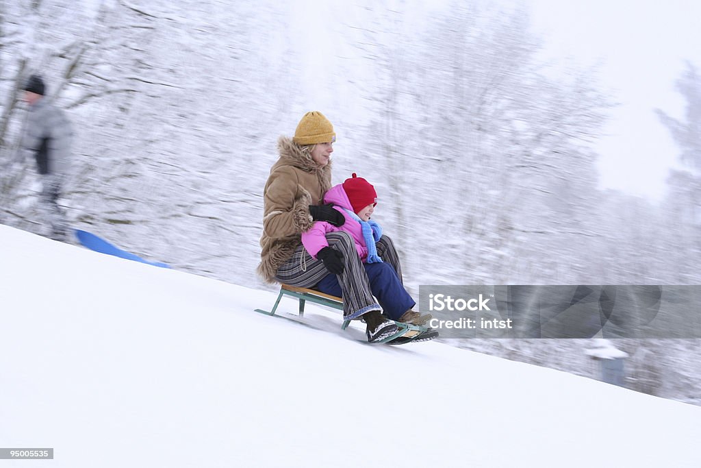 Madre e figlia sledging - Foto stock royalty-free di Andare giù