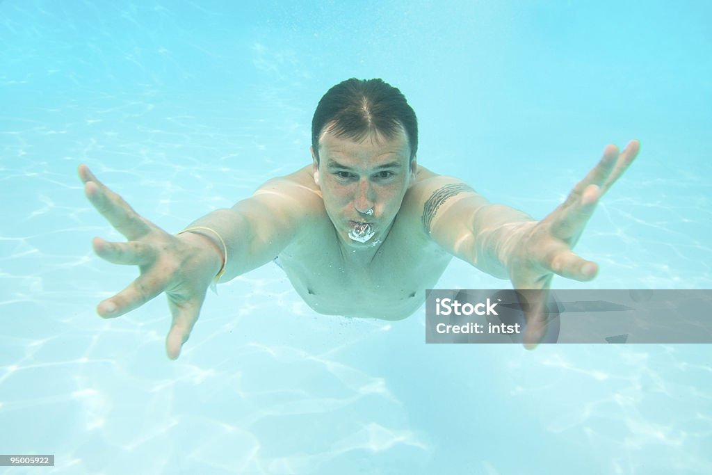 Hombre en la piscina bajo el agua - Foto de stock de 20 a 29 años libre de derechos