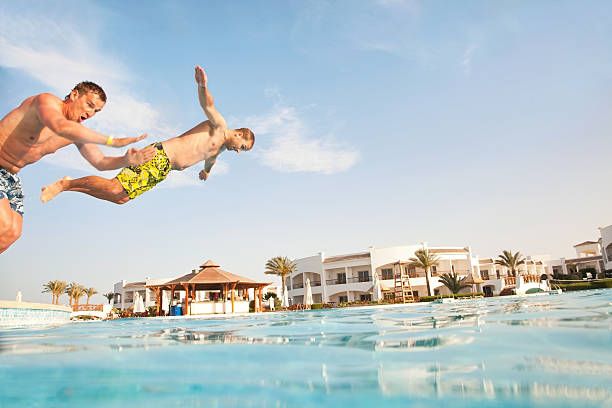 Two men having fun at swimming pool. stock photo