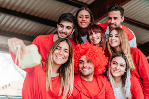 istock Fans at stadium together taking selfie with instant print camera 950062644