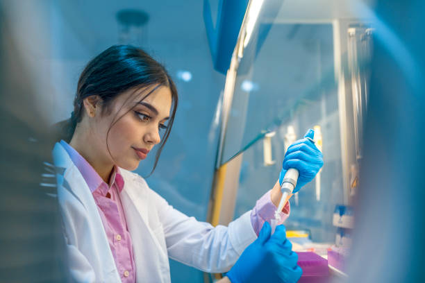 She's examining the evidence Female scientist with equipment and science experiments, Laboratory glassware containing chemical liquid, science research background. Photo of a student of chemistry working in laboratory. Scientist with dropper working at the laboratory fume cupboard stock pictures, royalty-free photos & images