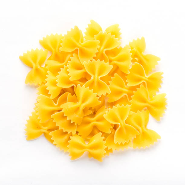 istock farfalle macaroni background with pasta on white isolated background with shadow. A view from the top, a close-up of a texture. 950111394