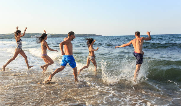 istock Friends jumping in the sea 950112124