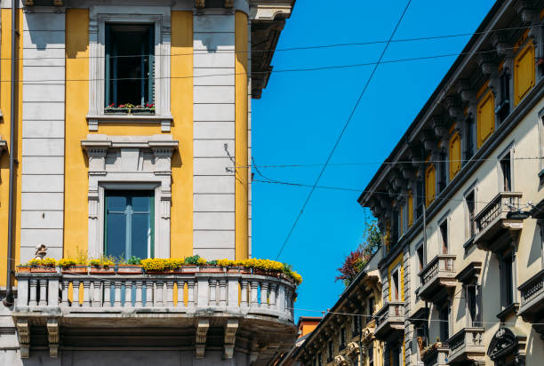 Vibrant Mediterranean colorful yellow building facade and balcony in Milan, Lombardy, Italy. stock photo