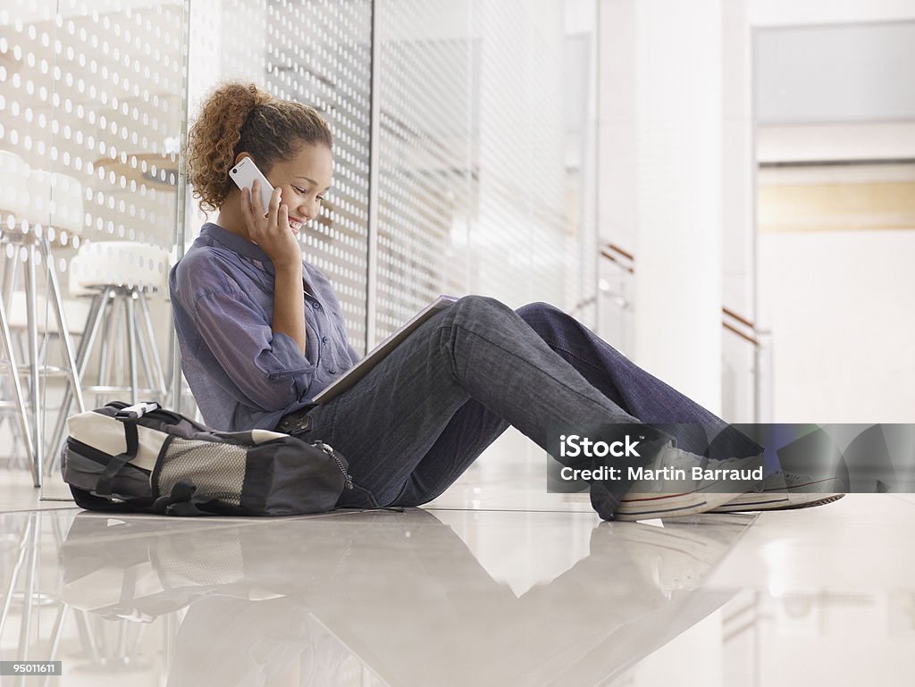 College-student auf dem Boden sitzen und sprechen auf Handy - Lizenzfrei Kapstadt Stock-Foto