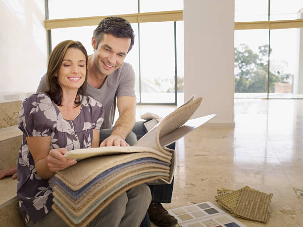 Couple looking at carpet samples in empty house  carpet sample stock pictures, royalty-free photos & images