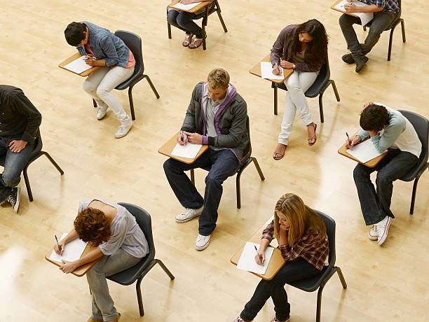 College students taking test in classroom  educational exam stock pictures, royalty-free photos & images