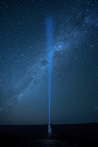 Flashlight lighting in the dark sky crossing southern Milky way, star gazing night photography concept