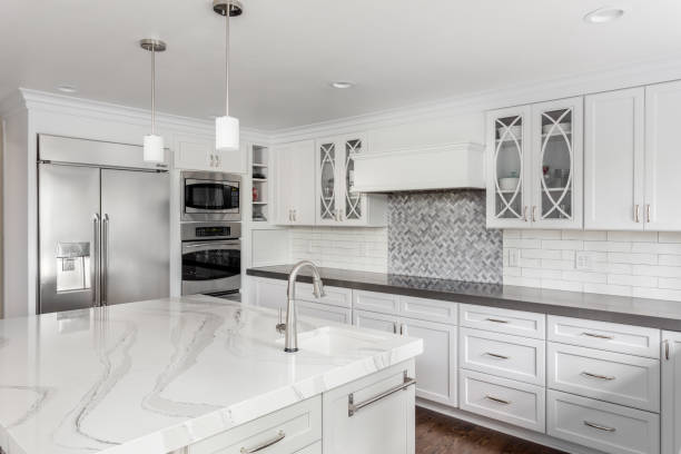 beautiful kitchen in new luxury home with island, pendant lights, and hardwood floors kitchen in newly constructed luxury home quartz stock pictures, royalty-free photos & images