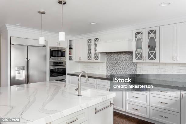 Beautiful Kitchen In New Luxury Home With Island Pendant Lights And Hardwood Floors Stock Photo - Download Image Now