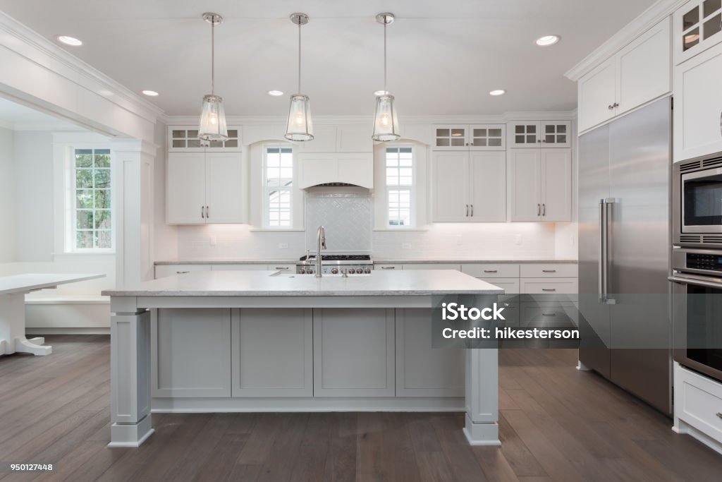 beautiful kitchen in new luxury home with island, pendant lights, and hardwood floors kitchen in newly constructed luxury home Kitchen Stock Photo
