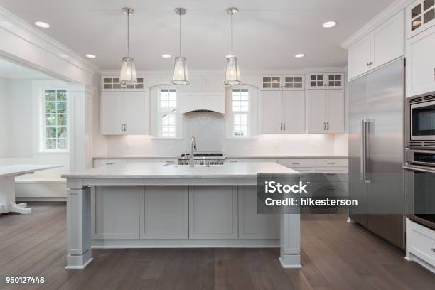 Beautiful Kitchen In New Luxury Home With Island Pendant Lights And Hardwood Floors Stock Photo - Download Image Now