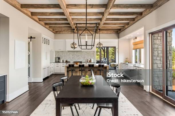 Stunning Kitchen And Dining Room In New Luxury Home Wood Beams And Elegant Pendant Lights Accent This Beautiful Openplan Dining Room And Kitchen Stock Photo - Download Image Now