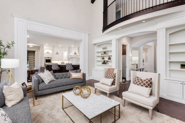 Beautiful living room interior with tall vaulted ceiling, loft area, hardwood floors and fireplace in new luxury home. Has view of kitchen and dining area, and loft. living room in newly constructed luxury home open plan stock pictures, royalty-free photos & images