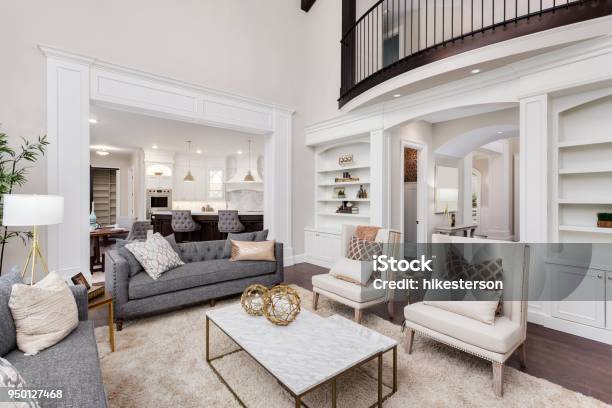 Beautiful Living Room Interior With Tall Vaulted Ceiling Loft Area Hardwood Floors And Fireplace In New Luxury Home Has View Of Kitchen And Dining Area And Loft Stock Photo - Download Image Now
