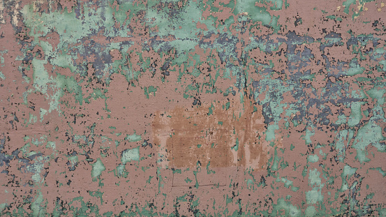 Old Brick wall with paint peeling. layers of color exposed