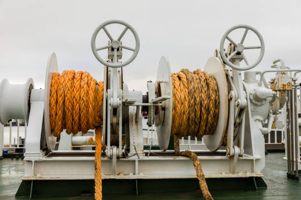istock Two winches with orange rope on a ferry, white cloudy backgrond 950152762