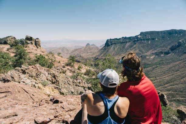 Man and woman sitting and looking at mountain view