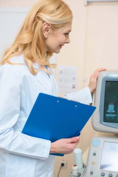 istock smiling doctor with clipboard touching ultrasonic scanner 950172256