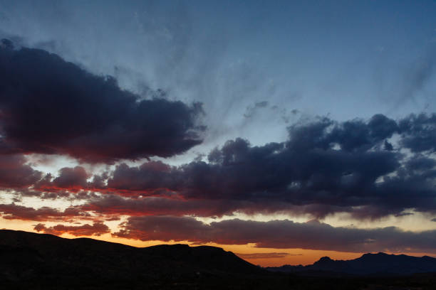 istock Dramatic sunset and sky over silhouette of desert landscape 950172928