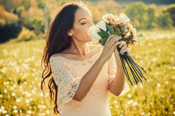 novia en un campo con un ramo de flores. - cut flowers women field single flower fotografías e imágenes de stock