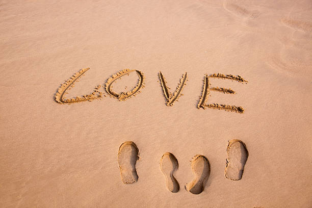 istock Footprint and Love written in the sand on a beach 95018342