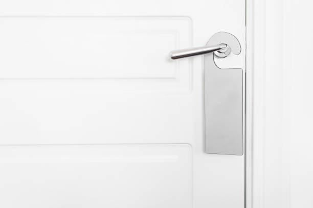 istock Door knob with empty label on a door handle for your text. Empty white flyer mockup hang on door handle. Leaflet design on entrance doorknob. Dont disturb sign. Hotel room clear hanger. blank 950183980