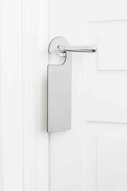 istock Door knob with empty label on a door handle for your text. Empty white flyer mockup hang on door handle. Leaflet design on entrance doorknob. Dont disturb sign. Hotel room clear hanger. blank 950186046