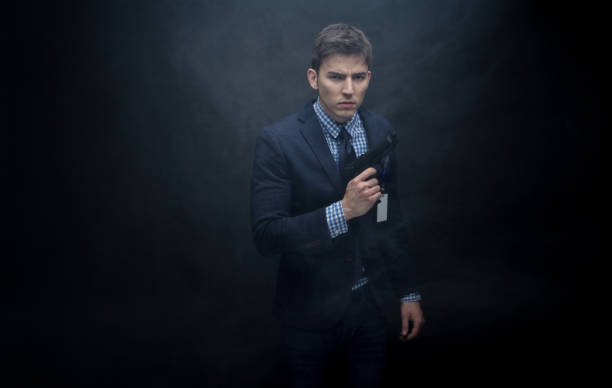 istock Well dressed businessman aiming a gun 950189084