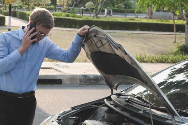 istock male agent examining engine for claiming auto insurance. caucasian man calling for assistance for car damaged by traffic accident 950196910