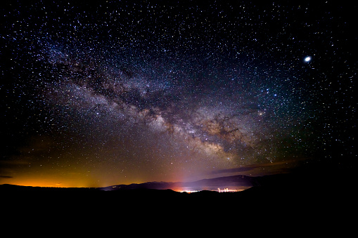 Town Lit Up with Milky Way Galaxy Scenic Mountain Landscape - Very dark skies reveal the vast Milky Way Galaxy.
