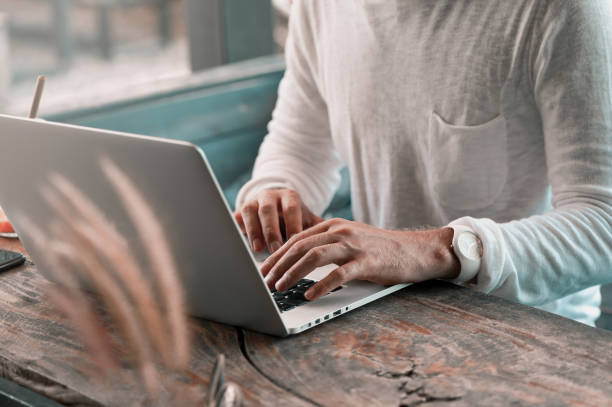 istock Young male freelancer sitting in cafe working in laptop 950223550