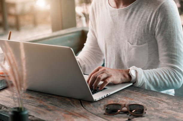istock Young male freelancer sitting in cafe working in laptop 950223574