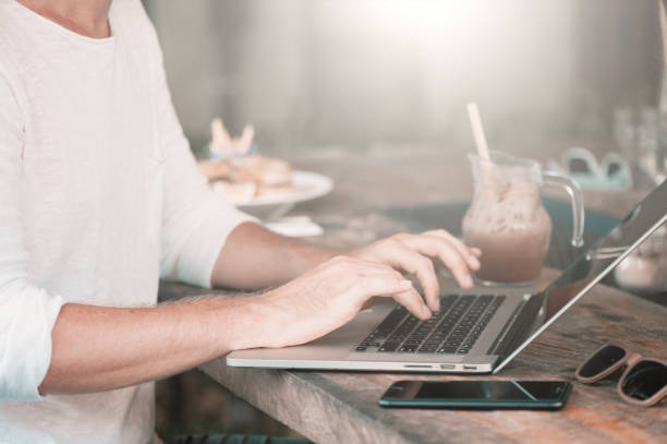 istock Young male freelancer sitting in cafe working in laptop 950223744
