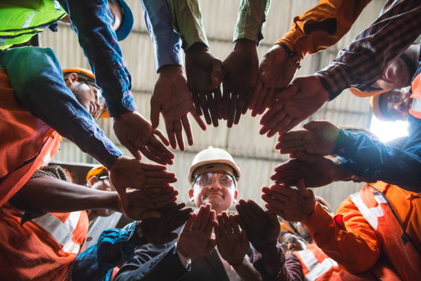 団結のためのサークルに一緒に来てください。 - construction worker hardhat safety manual worker ストックフォトと画像