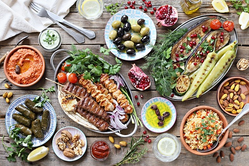 Mesa del Medio Oriente, Árabe o mediterránea con kebab de cordero, pinchos de pollo con verduras asadas y variedad de aperitivos que sirve en la mesa de jardín rústica. photo