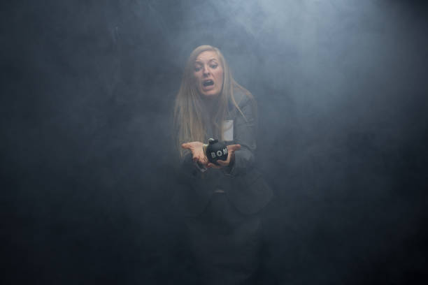 femme tenant une bombe - smoke one person detonator exploding photos et images de collection