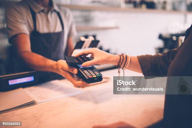 Young Hipster Woman Paying Using Nfc Smartphone Contactless Technology Stock Photo - Download Image Now