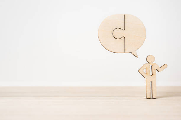 istock wooden businessman icon with jigsaw dialogu 950271312
