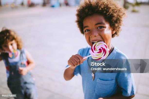 Multiethnische Brüder Bunte Lutscher Im Sommer Im Freien Zu Essen Stockfoto und mehr Bilder von Süßigkeit