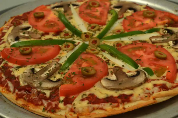 Vegetarian pizza with vegetable beddings, cheese and tomato sauce served in a nice restaurant