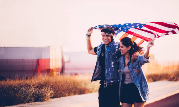 istock Young friends running in streets with an American flag 950292902